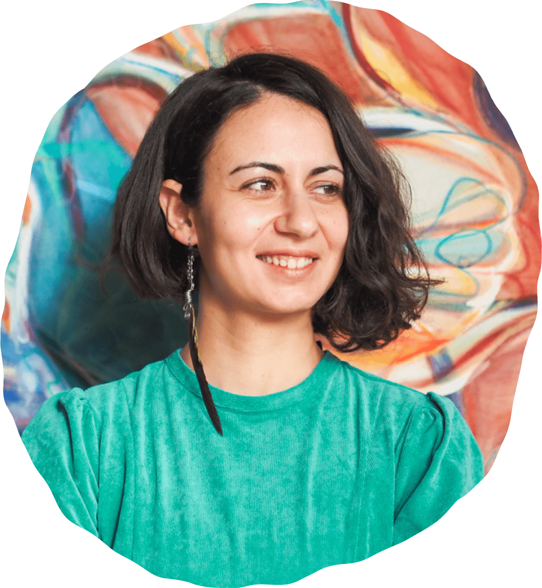 Adamantia Klonaris smiling in front of a colorful abstract painting.